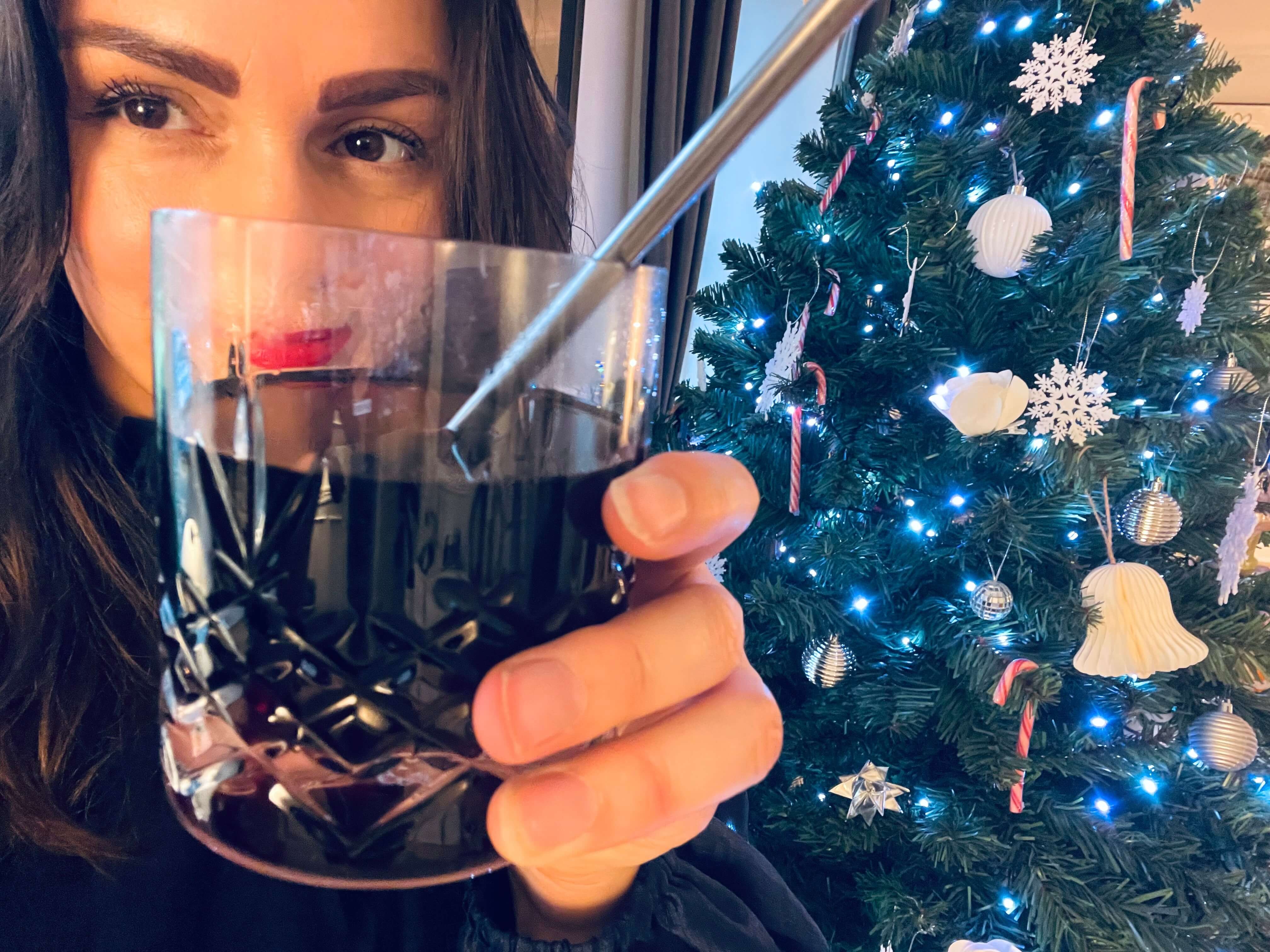 Kvinde med Blossa vingløgg foran juletræ